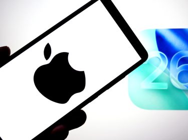 Auf dieser Fotoillustration ist ein Apple-Logo auf einem Smartphone mit einem IOS 26-Logo im Hintergrund zu sehen.