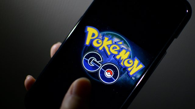 Eine Hand hält ein Smartphone, auf dem das "Pokémon GO"-Logo zu sehen ist.