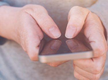 Auf dem Bild zum Thema Google Pixel Akku tauschen hält eine Person ein Smartphone mit beiden Händen im Querformat. Der Fokus liegt auf den Fingern, die präzise das Display bedienen. Die Nahaufnahme vermittelt eine ruhige, konzentrierte Stimmung und steht symbolisch für technische Handgriffe oder Reparaturvorgänge am Gerät.