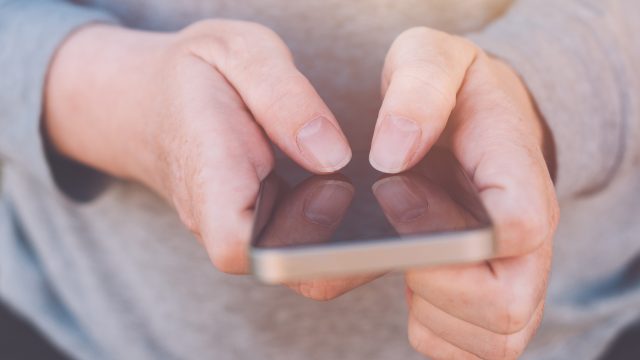 Auf dem Bild zum Thema Google Pixel Akku tauschen hält eine Person ein Smartphone mit beiden Händen im Querformat. Der Fokus liegt auf den Fingern, die präzise das Display bedienen. Die Nahaufnahme vermittelt eine ruhige, konzentrierte Stimmung und steht symbolisch für technische Handgriffe oder Reparaturvorgänge am Gerät.