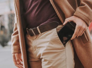 Mann steckt Smartphone in die Hosentasche