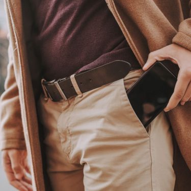 Mann steckt Smartphone in die Hosentasche