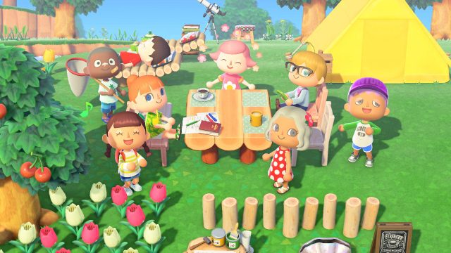 In dieser sommerlichen Szene aus Animal Crossing: New Horizons sitzen verschiedene Charaktere rund um einen Picknicktisch im Grünen. Einige unterhalten sich, andere entspannen in Liegestühlen oder halten ein Fangnetz in der Hand. Im Hintergrund steht ein gelbes Zelt. Die fröhliche Camp-Atmosphäre passt ideal zur Vorfreude auf Animal Crossing für die Switch 2.