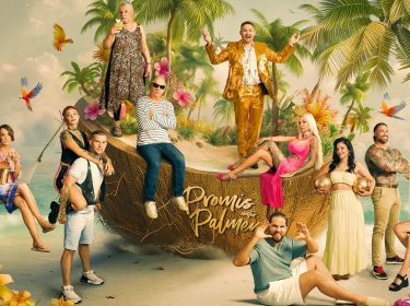 Auf dem Bild zur Reality-Show Promis unter Palmen 2026 sind die Kandidat:innen in einer farbenfrohen Kulisse mit Palmen, Papageien und einer übergroßen Kokosnuss inszeniert.