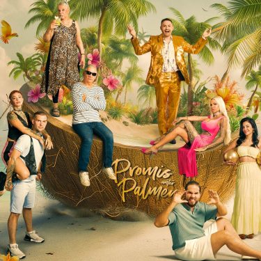 Auf dem Bild zur Reality-Show Promis unter Palmen 2026 sind die Kandidat:innen in einer farbenfrohen Kulisse mit Palmen, Papageien und einer übergroßen Kokosnuss inszeniert.