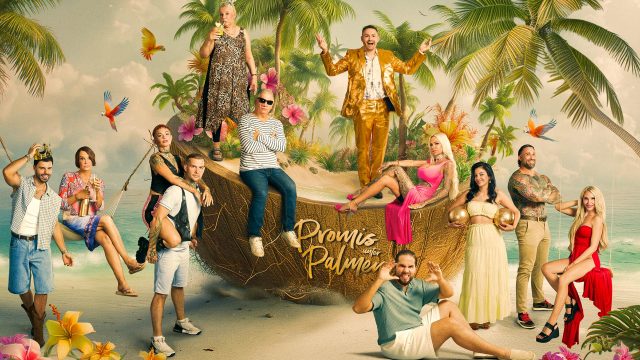 Auf dem Bild zur Reality-Show Promis unter Palmen 2026 sind die Kandidat:innen in einer farbenfrohen Kulisse mit Palmen, Papageien und einer übergroßen Kokosnuss inszeniert.