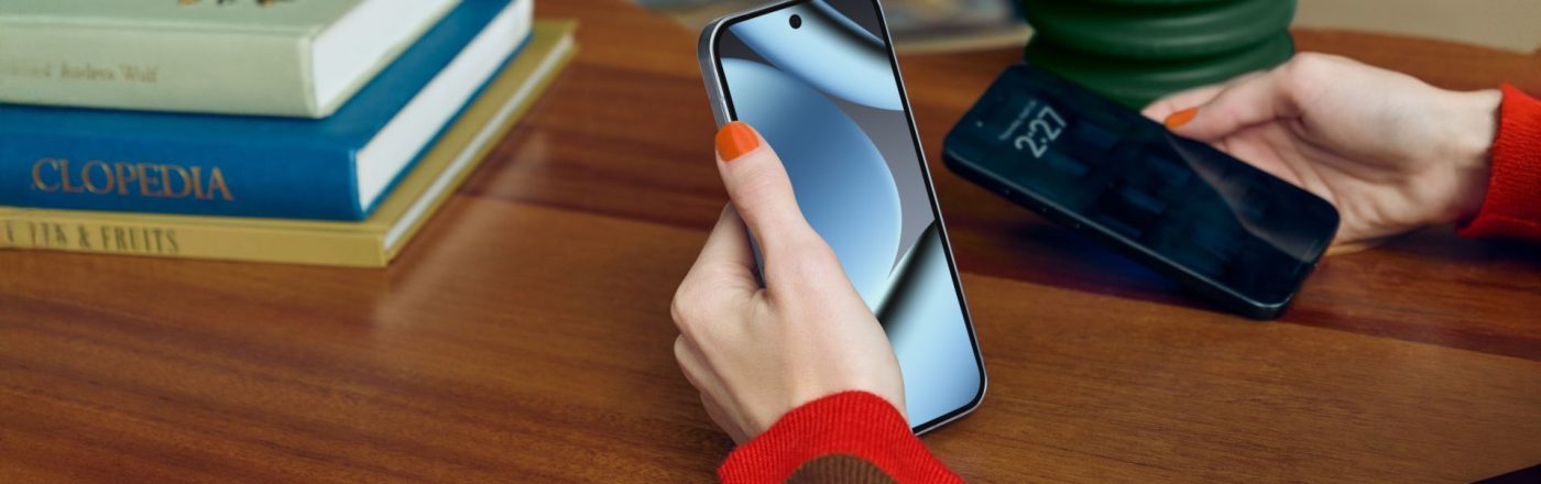 Eine Hand hält das Google Pixel 10 Pro, im Hintergrund ein dunkler Holzschreibtisch mit Büchern.