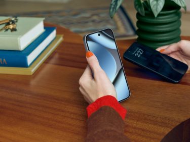 Eine Hand hält das Google Pixel 10 Pro, im Hintergrund ein dunkler Holzschreibtisch mit Büchern.