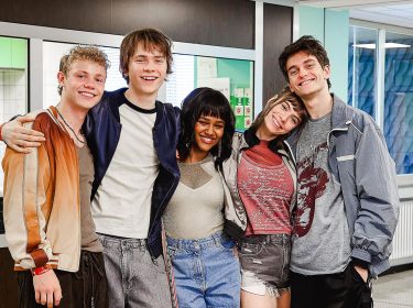 Auf dem Bild in dem Artikel zu Club der roten Bänder – Die neue Generation posieren fünf junge Darsteller:innen in einem Flur.