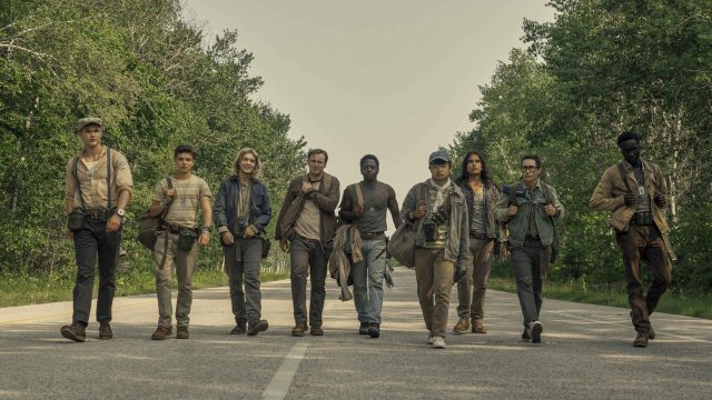 Mehrere junge Männer gehen in einer Reihe eine Straße entlang.