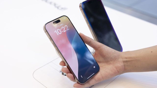 Hand hält im Apple Store ein iPhone 16 Pro in die Kamera.