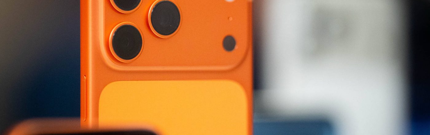 Die obere Hälfte des iPhone 17 Pro in Cosmic Orange, im Hintergrund weitere iPhones.