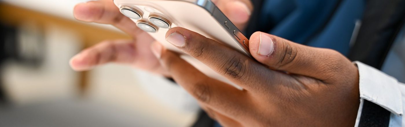 Eine Person hält ein iPhone in der Hand.