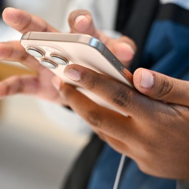 Eine Person hält ein iPhone in der Hand.