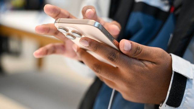 Eine Person hält ein iPhone in der Hand.