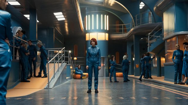 Asia (Alicia Falcó) steht im Bunker, im Hintergrund weitere Bewohner.