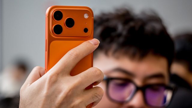 Hand hält das orange iPhone 17 Pro in die Kamera.