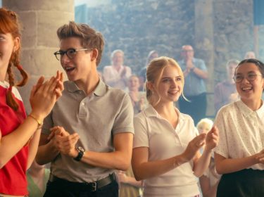 Vier Schüler und Schülerinnen klatschen in die Hände.