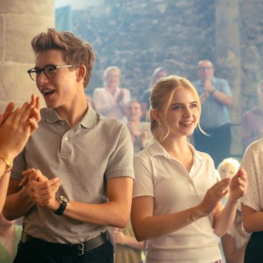 Vier Schüler und Schülerinnen klatschen in die Hände.