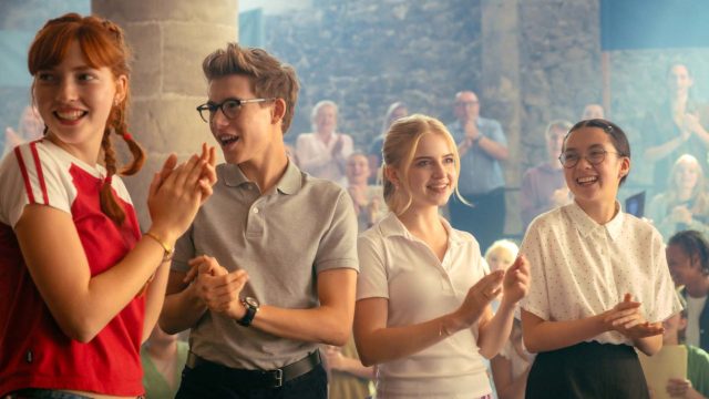 Vier Schüler und Schülerinnen klatschen in die Hände.