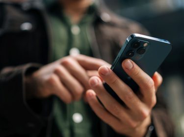 Mann tippt auf ein iPhone.