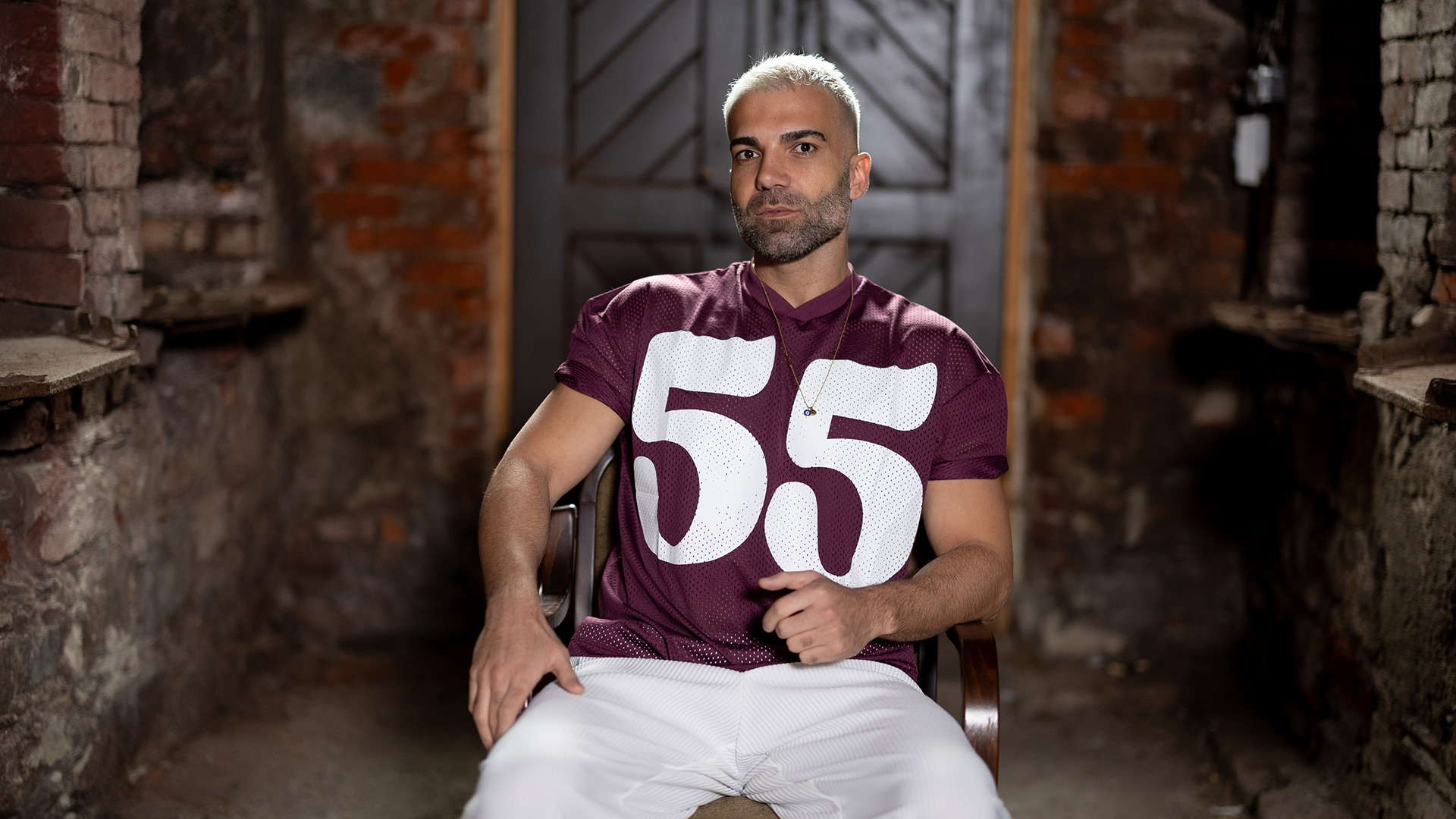 Auf dem Bild zu „Das große Promi-Büßen“ 2025 sitzt Rafi Rachek in lässiger Pose auf einem Stuhl.