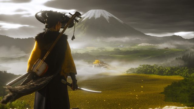 Die Protagonistin Atsu aus dem Spiel Ghost of Yotei steht mit einem Katana in der Hand vor einer weiten, nebligen Landschaft. Im Hintergrund ragt ein schneebedeckter Vulkan auf, bei dem es sich wahrscheinlich um den Mount Yōtei handelt – eine Szene, die sich ideal für atmosphärische Ghost of Yotei-Tipps eignet.