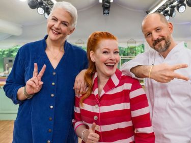 Moderatorin Enie van de Meiklokjes und die Juroren Bettina Schliephake-Burchardt und Christian Hümbs posieren in der Backstube.