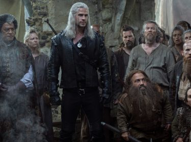 Liam Hemsworth als Geralt von Riva, umringt von weiteren Charakteren.