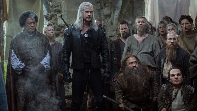Liam Hemsworth als Geralt von Riva, umringt von weiteren Charakteren.