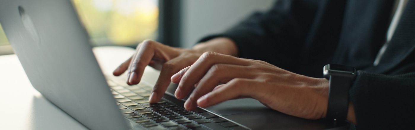 Auf dem Bild mit symbolischem Bezug zu Perplexity Pro ist eine Person in Business-Kleidung zu sehen, die konzentriert auf einem modernen Laptop tippt. Die Szene wirkt professionell und fokussiert, im Hintergrund ist ein Fenster mit natürlichem Licht und unscharfem Ausblick zu erkennen. Am Handgelenk trägt die Person eine Smartwatch.