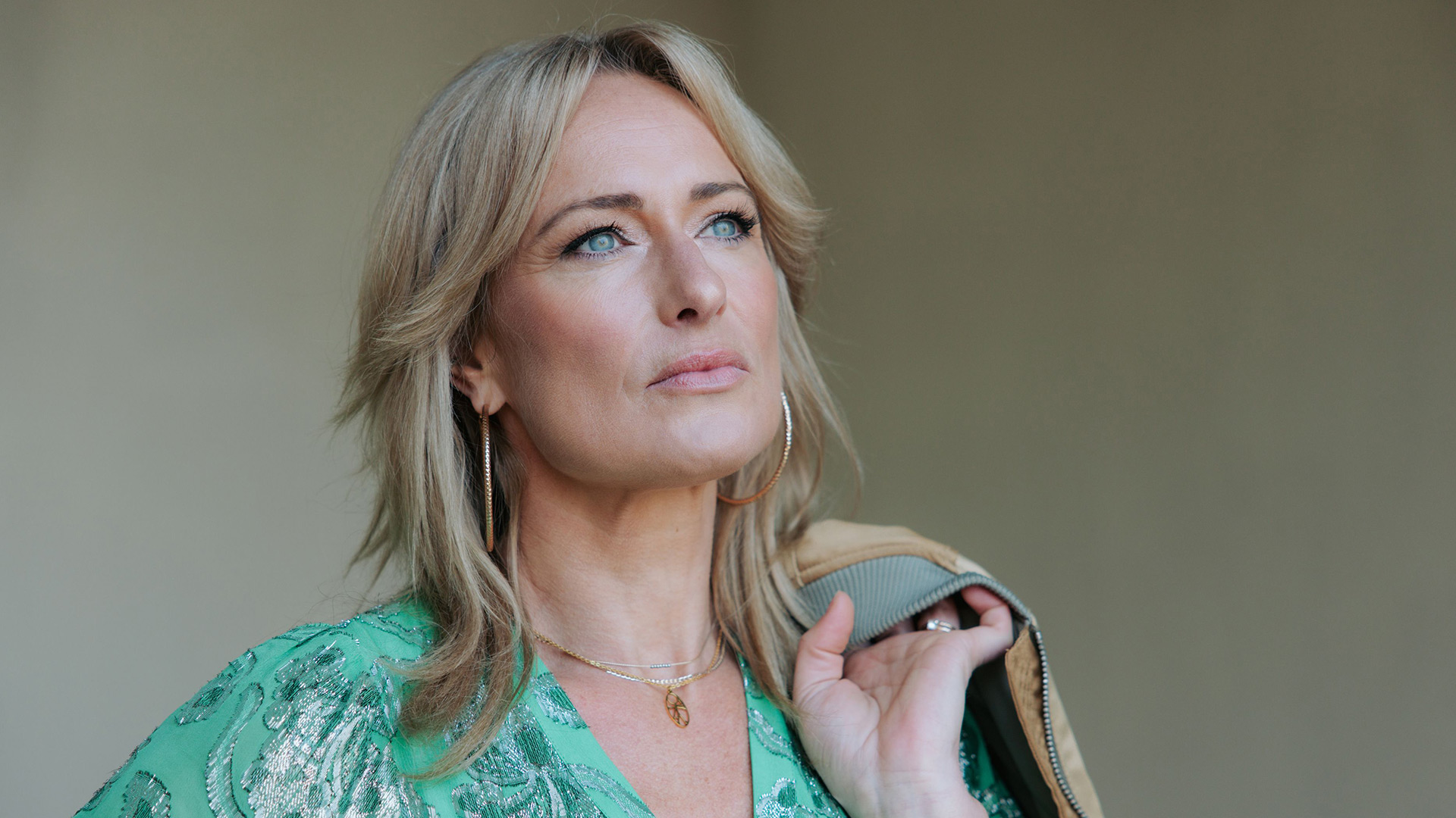 Dieses Bild zur GZSZ-Besetzung zeigt Eva Mona Rodekirchen. Sie trägt ein grünes Kleid und hält sich eine Jacke über die Schulter.