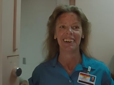 Aileen: Queen of the Serial Killers: Aileen Wuornos schaut lachend nach links, während sie Gefägniskleidung trägt.
