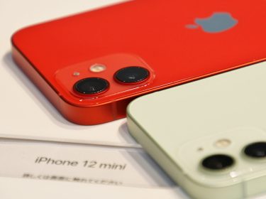 Nahaufnahme zweier iPhone 12 mini - eins in rot, eins in weiß.