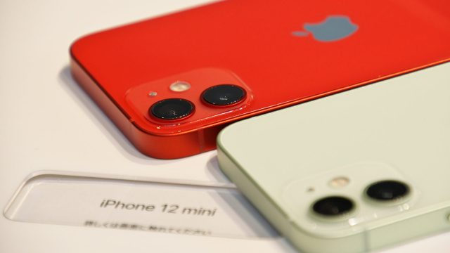 Nahaufnahme zweier iPhone 12 mini - eins in rot, eins in weiß.