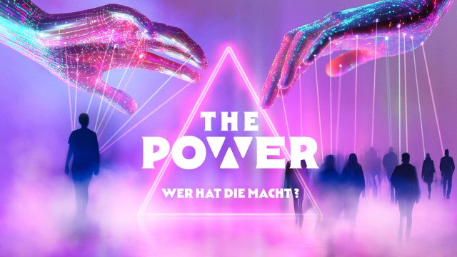 Auf dem offiziellen Visual zu "The Power" von Joyn schweben zwei leuchtende, digitale Hände über einer Gruppe von Menschen, die im Nebel auf eine neonbeleuchtete Pyramide zulaufen. Die Hände steuern die Figuren wie Marionetten. Die Farben sind dominiert von Violett, Pink und Blau, was eine mysteriöse und futuristische Stimmung erzeugt.