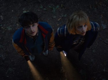 In den Streaming-Highlights im November 2025 siehst du eine Szene aus Stranger Things Staffel 5. Auf dem Bild sind Noah Schnapp als Will Byers und Maya Hawke als Robin Buckley zu sehen. Beide blicken an einem dunklen Ort mit ernster Miene nach oben, ihre Taschenlampen werfen Licht auf den Boden.