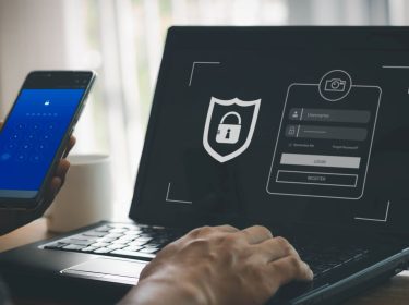 Ein Mann tippt Passwort und E-Mail-Adresse am Laptop ein.