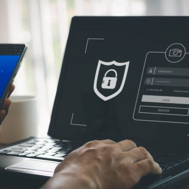 Ein Mann tippt Passwort und E-Mail-Adresse am Laptop ein.