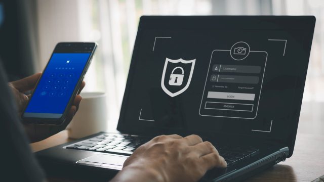 Ein Mann tippt Passwort und E-Mail-Adresse am Laptop ein.