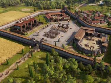 Im Screenshot aus Anno 117: Pax Romana ist eine römische Militäranlage zu sehen, umgeben von einer massiven Steinmauer mit Wachtürmen. Im Innenhof formieren sich Legionäre und Reiter in präziser Formation, flankiert von Katapulten. Rechts liegt ein befestigter Kommandoposten, links Werkstätten und Ställe.