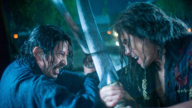 Szenenbild aus der Serie Last Samurai Standing: Zwei Kämpfer mit nassen Haaren liefern sich im strömenden Regen einen intensiven Schwertkampf, ihre Klingen blockieren sich in einem kraftvollen Schlagabtausch.