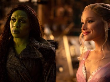 Auf dem Bild in dem Artikel zur „Wicked: Teil 2“-Kritik stehen Glinda, gespielt von Ariana Grande, und Elphaba, gespielt von Cynthia Erivo, nebeneinander.