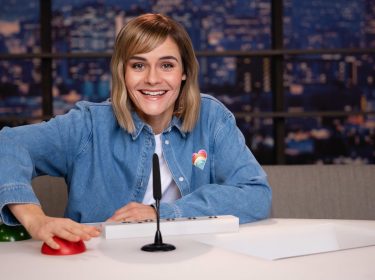 Hazel Brugger posiert mit einem roten Buzzer am Set von 