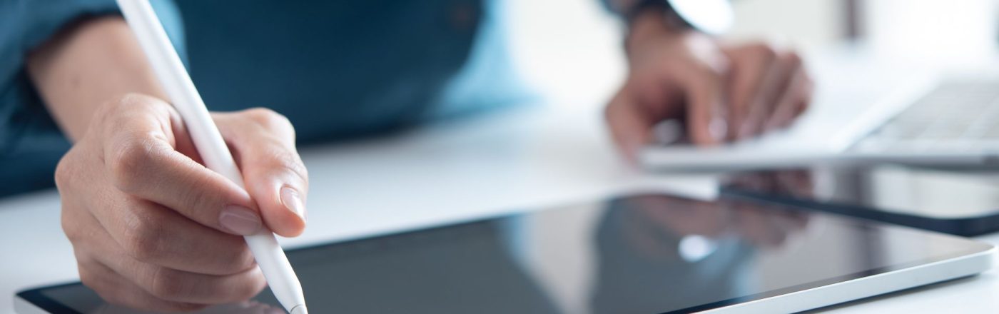 Mann schreibt mit Eingabestift auf seinem iPad-Display.