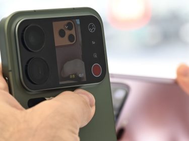 Mann hält das Xiaomi 17 Pro mit Zweitdisplay auf der Rückseite hoch.