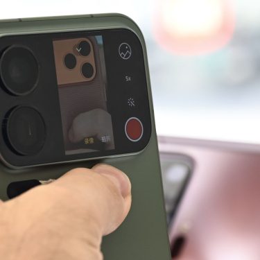 Mann hält das Xiaomi 17 Pro mit Zweitdisplay auf der Rückseite hoch.