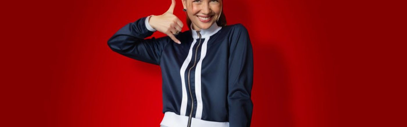 Auf dem Bild in dem Artikel zu den CallYa-Jahrespaketen und den Upgrades ist eine junge Frau vor rotem Hintergrund zu sehen. Sie trägt eine dunkelblaue Jacke und eine helle Jeans.