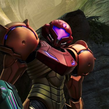 Auf dem Bild zu Metroid Prime 4: Beyond Tipps ist die Kopfgeldjägerin Samus Aran in ihrer ikonischen Power-Rüstung zu sehen. Sie steht leicht seitlich in einer felsigen, außerirdisch wirkenden Umgebung mit moosbewachsenen Wänden und geheimnisvollen Lichtstrahlen. Ihre Pose wirkt selbstbewusst und entschlossen – bereit für den nächsten Einsatz.