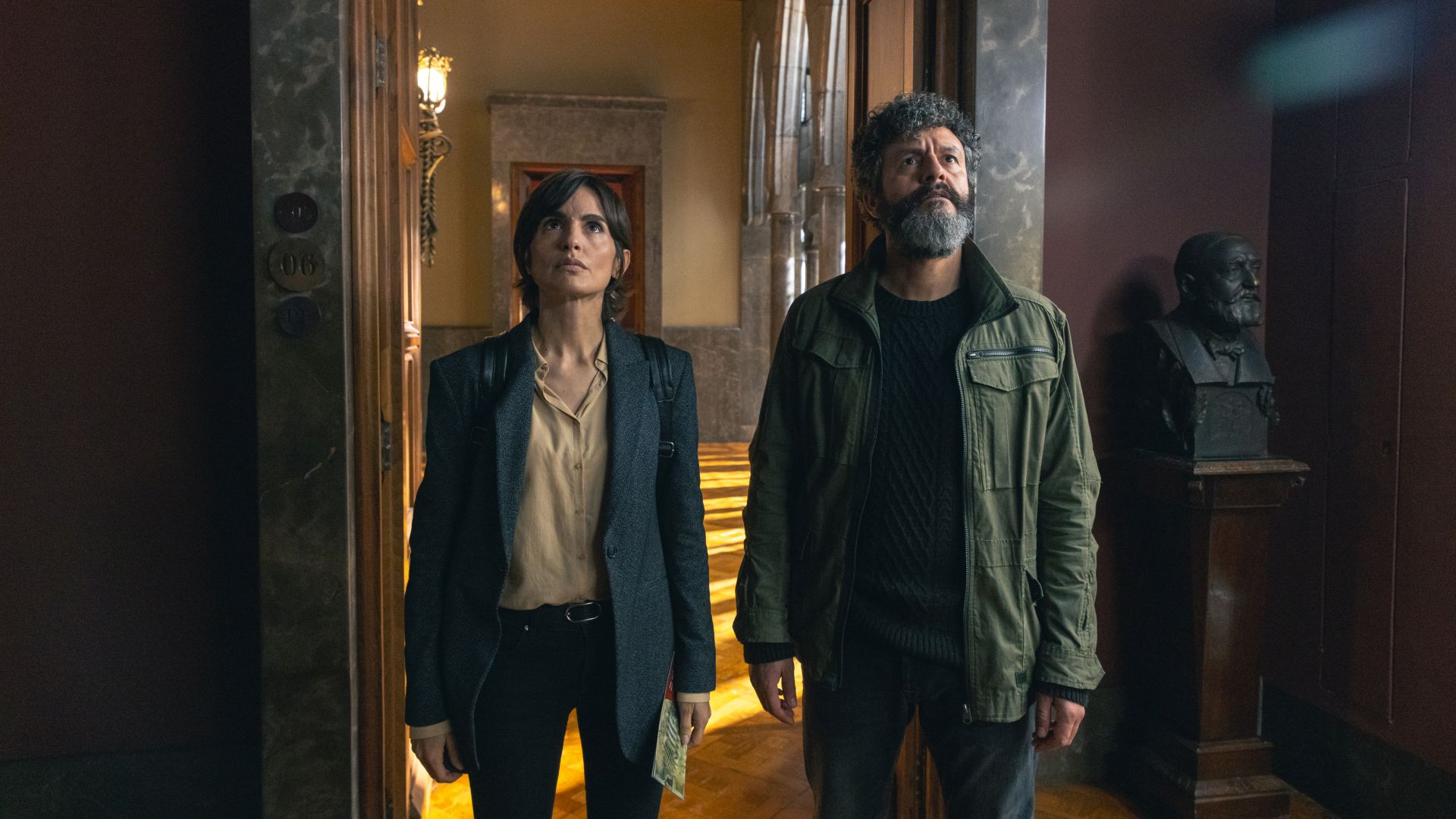 Verónica Echegui als Rebeca Garrido und Isak Férriz als Milo Malart schauen in einer Szene von "Stadt der Schatten" nach oben zur Decke.